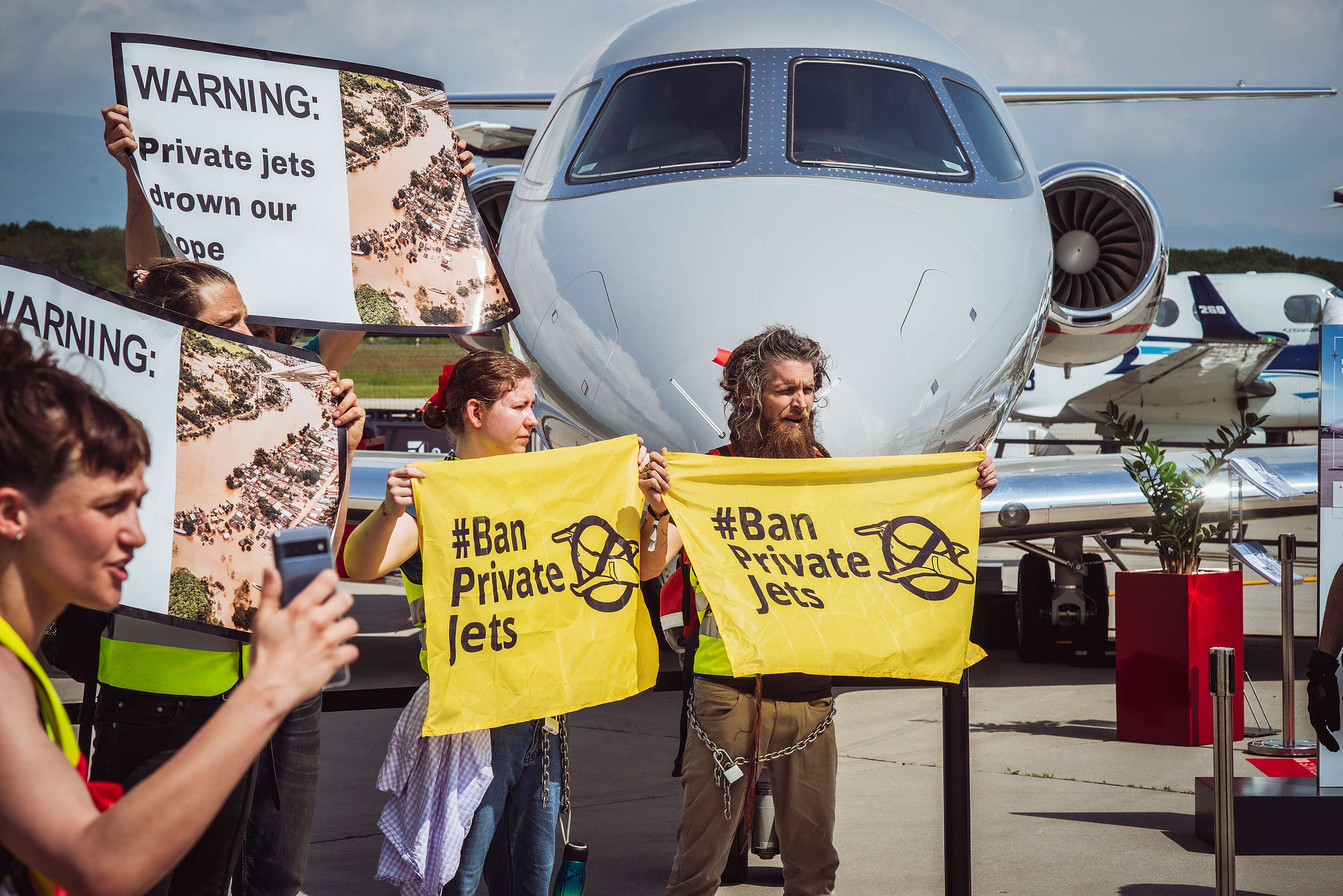 A hundred climate activists block private jets at biggest business aviation sales event in Europe, protesting luxury mega-polluters